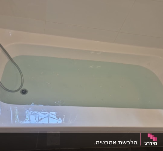 אמבטיה עם מים ודוש בצד שמאל